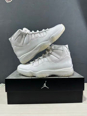 Pair of white high-top sneakers arranged on a black Jordan shoebox, showing the side profiles.