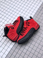Pair of red and black high-top sneakers displayed on a metal grid surface.