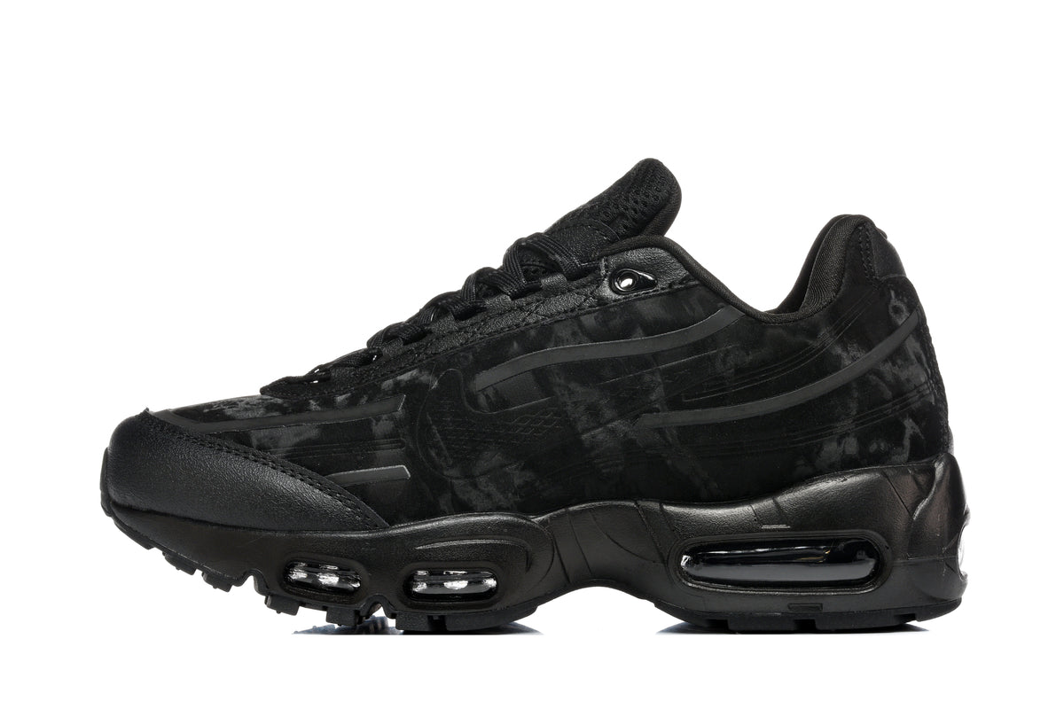 Side view of a black Nike Air Max 95-style sneaker with a dark camouflage-patterned upper and visible midsole cushioning windows.