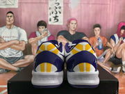 Rear view showing purple heel panels, yellow-and-white heel accents, and white midsoles.