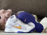 White and purple high-top sneakers displayed together, including a visible patterned purple outsole with a gold Swoosh mark.