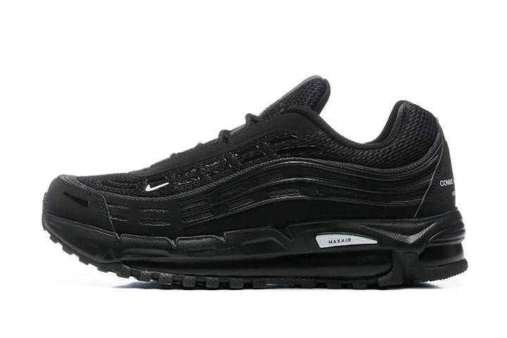 Side view of a black Nike Air Max 97-style sneaker with layered wavy panels and small white Swoosh detail.