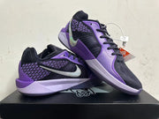 Pair of black and purple basketball shoes shown together, with silver Swooshes and patterned side panels.