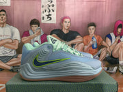 Side profile of one Nike basketball sneaker showing the layered outsole and blue, green, and lime color details.