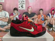 Side view of a red and black Nike basketball sneaker showing the Swoosh, patterned red upper, black midsole structure, and low-top profile.