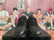 Front view of black Nike Air Max sneakers with dark red accents