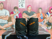 Rear view of black basketball shoes showing orange “TWELVE” heel lettering.