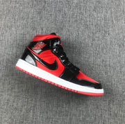 Side view of a red and black Jordan Air Jordan 1 Mid sneaker with glossy black overlays and a white midsole.