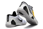 White and black Kobe 9 Low basketball shoes shown from the heel and outsole.