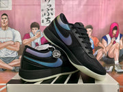 Pair of black low-top sneakers with iridescent blue, purple, and green side details displayed on a shoebox.