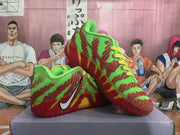 Pair of green and red Nike sneakers shown at an angled view with yellow laces and contrasting red soles.