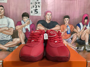 Front view of red Nike sneakers showing the lace-up design, perforated forefoot panels, and branded toe areas.