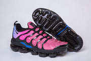 Nike sneaker beside an upturned shoe showing the dark segmented-looking sole.