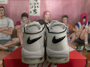Rear view of a pair of white and black Nike high-top sneakers with chunky soles.