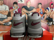 Rear view of grey and white sneakers with burgundy heel logos and visible cushioning