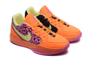 Three-quarter view of the orange and pink Jordan sneakers showing the lace-up design and contrasting panels.