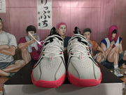 Front view showing the white perforated uppers, white laces, black accents, and pink outsoles.