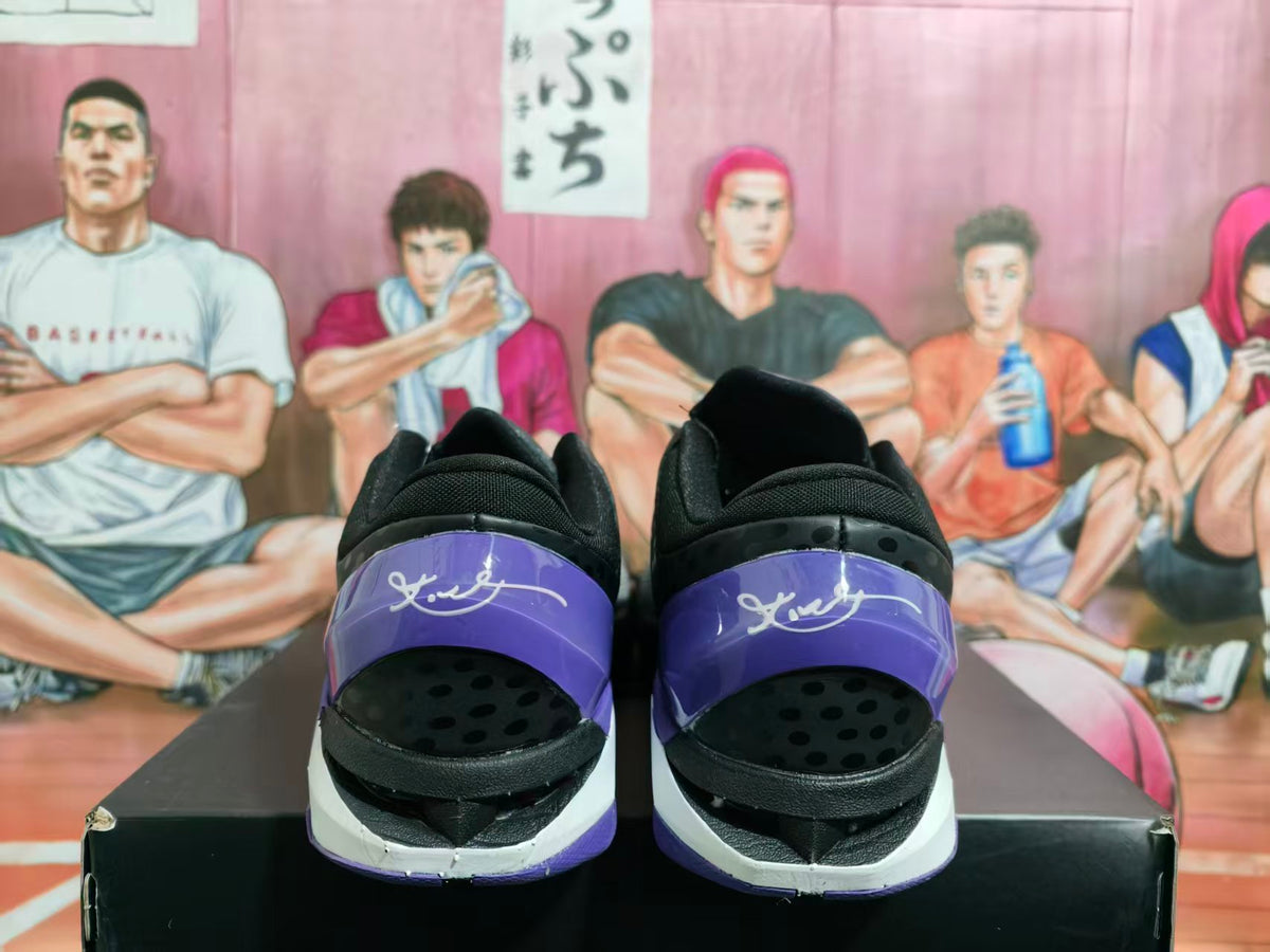 Rear view of gray, purple, and black basketball sneakers displayed on a black box.