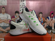 Angled view of Nike basketball shoes with green lace details and speckled soles