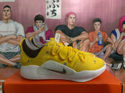 Side view of a yellow and white Nike sneaker with a grey Nike Swoosh detail and visible LeBron text.
