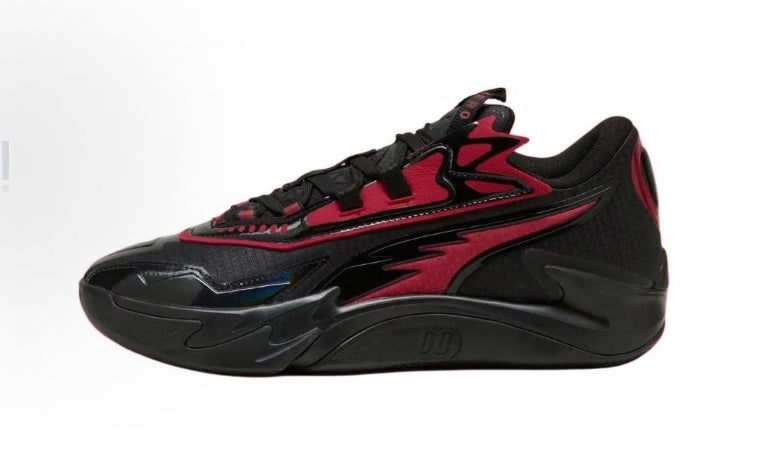 Side view of black low-top sneakers with red accents, layered side panels and a sculpted black outsole.