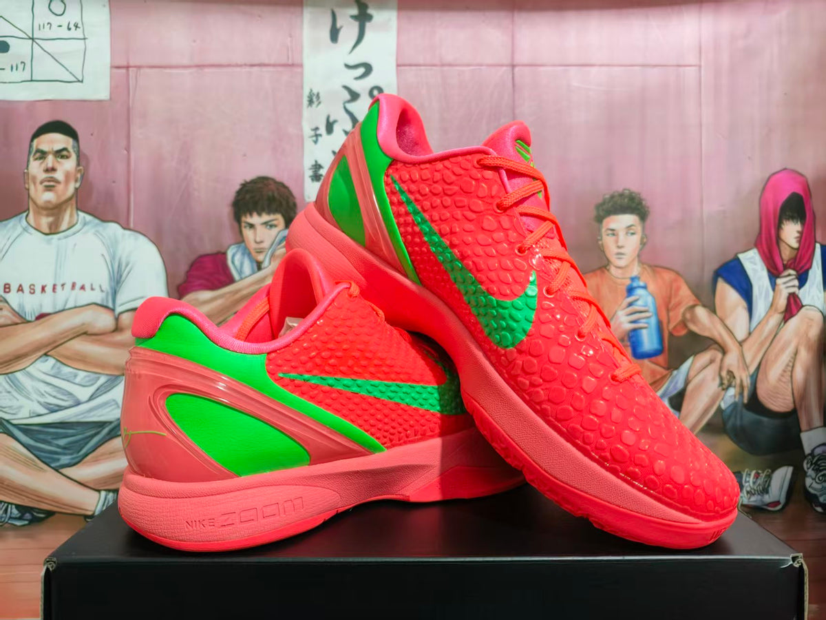 Pair of coral and green Nike Kobe PE basketball shoes, shown from an angled side view