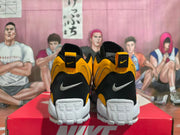 Rear view of yellow and black Nike sneakers with white heel panels