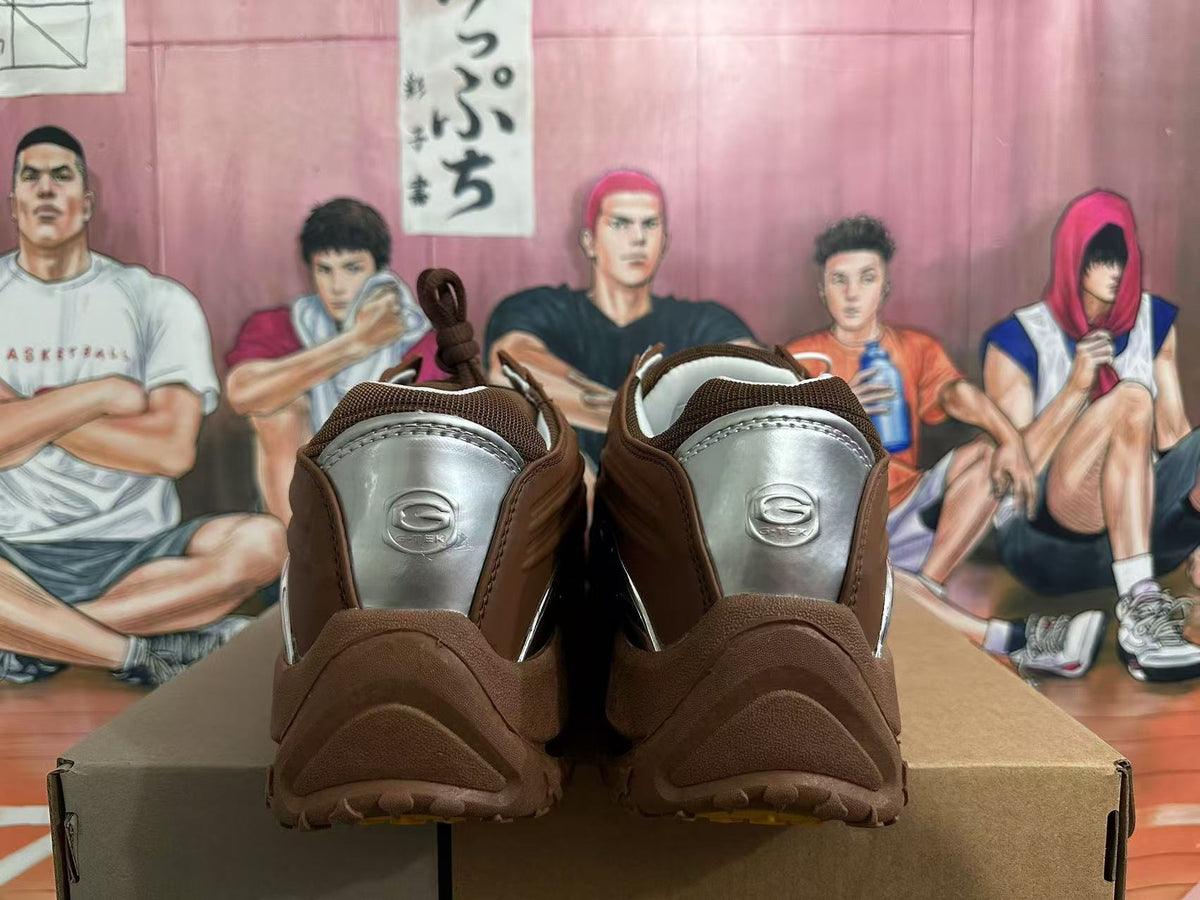 Rear view of brown sneakers with silver-toned heel panels and a chunky outsole