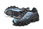 Pair of black and blue Nike Shox TL sneakers in a three-quarter view.