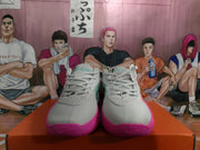 Front view of white Nike basketball sneakers showing laces, perforated toe panels and pink outsoles.