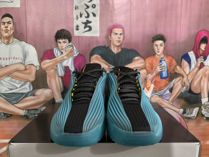 Pair of blue, black, and red basketball-style sneakers shown from the front on a box.
