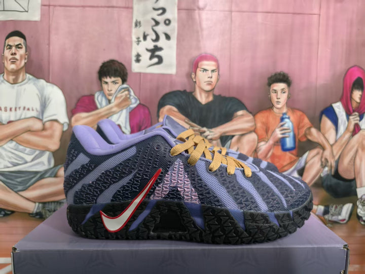 Dark blue Nike basketball sneakers with lavender accents and gold laces shown from the side on a shoebox.