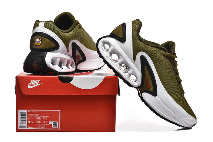 Olive green Nike Air Max DN sneakers displayed with a red shoe box; the box label shows size details.