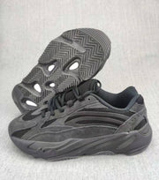 Charcoal and gray 700 V2 sneaker shown from the side with the patterned outsole visible.