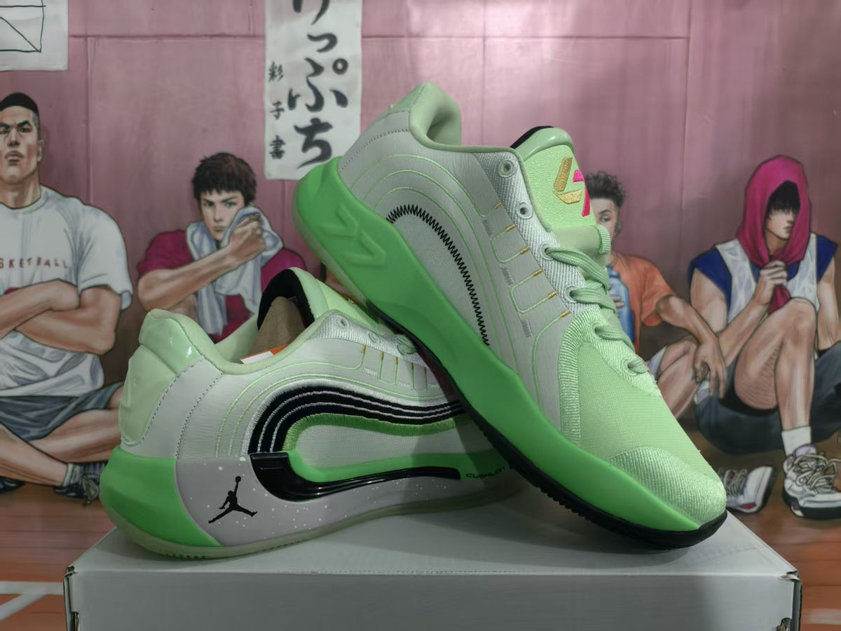 Pair of mint green and light gray Jordan basketball sneakers displayed on a shoebox, showing the side detailing and green outsole.