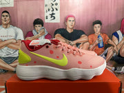 Side view of a pink Nike basketball shoe with coral-red dots, a volt Swoosh and heel panel, and a white ridged outsole.