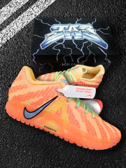 Angled product view showing the orange-red Nike sneakers, green laces, patterned upper, and visible product tag.