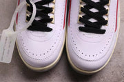 Close-up of the perforated white toe boxes, black laces, and an attached alternate lace tag.
