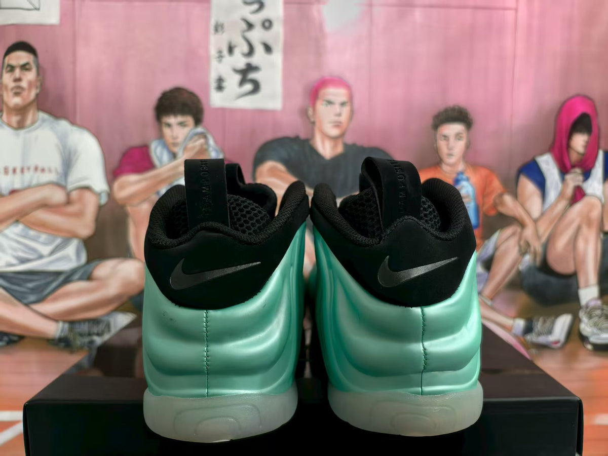 Rear view of mint green and black Nike sneakers with black heel tabs and translucent soles.