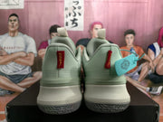 Rear view of pale green Nike basketball sneakers showing heel tabs, padded collars, layered midsoles, and ribbed outsoles.