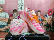 Angled view of the paired sneakers highlighting the pink upper details, orange laces, and side branding.