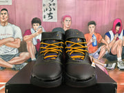 Front view of black basketball sneakers with yellow laces, purple tongue accents, padded collars, and ankle straps.