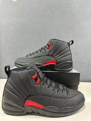 Close three-quarter view of black and red high-top sneakers with textured forefoot panels.