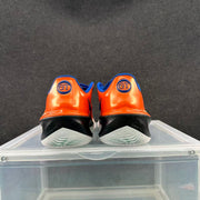 Rear view of orange Nike GT basketball shoes with black heel sections