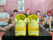 Rear view of the yellow sneakers showing heel graphics, padded collars, and speckled midsoles.