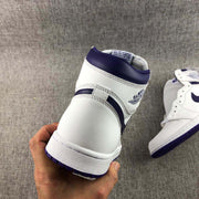 Close rear view showing the heel panel, collar trim, stitching, and purple outsole edge.