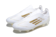 Pair of white adidas F50 laceless soccer cleats with gold-colored accents, viewed from the side.