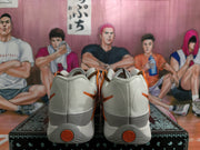 Rear view of white and grey Nike sneakers with orange heel accents and orange circular heel details.