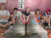 Rear view of pink and light grey Adidas sneakers showing heel details, pull tabs and BOOST lettering on the soles.