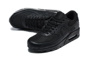Angled top view of a pair of black Nike Air Max 90 sneakers.